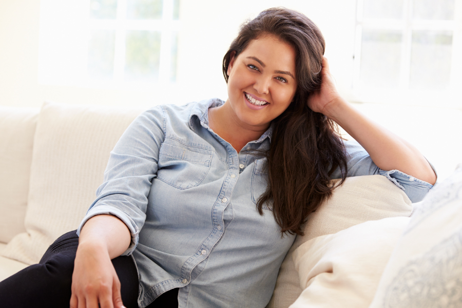 medium sized woman sitting on couch smiling